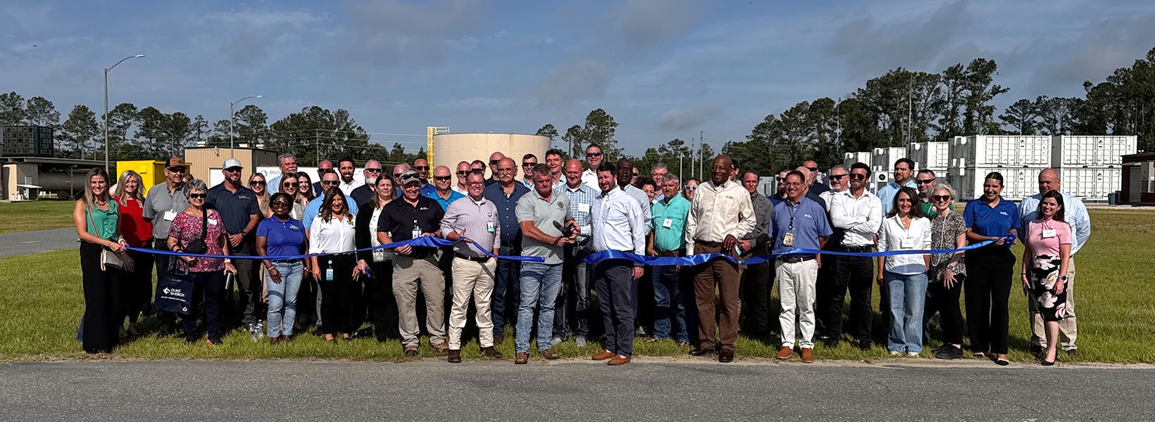community members pose for a picture at a ribbon cutting
